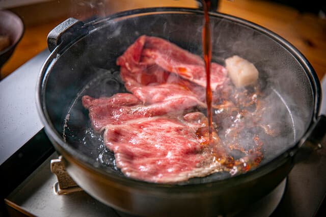 Sukiyaki to Gyumabushi Momoshiki: Yamato-Rindfleisch Sukiyaki und Mabushi